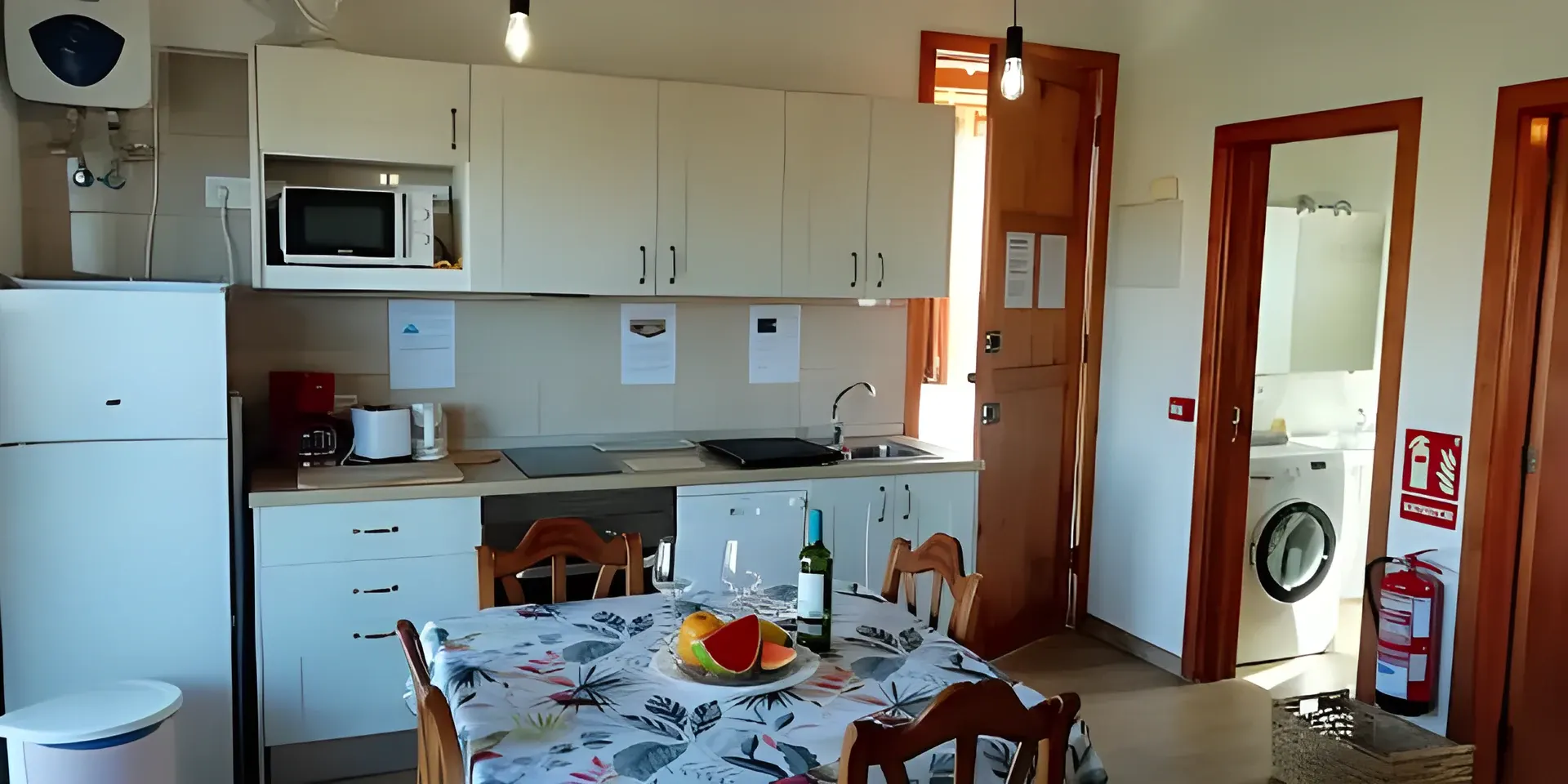 Cocina equipada con lavadora y mesa de comedor del apartamento